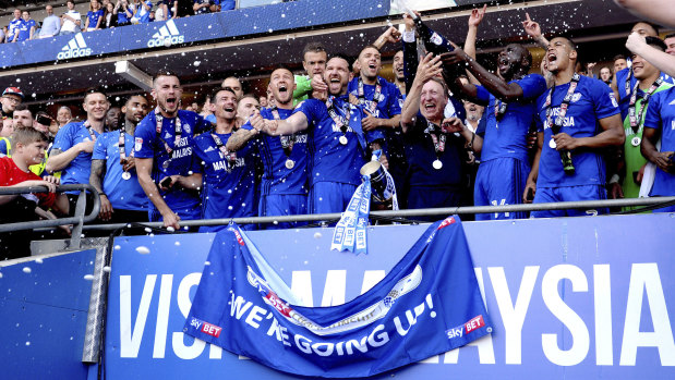 Cardiff City manager Neil Warnock (centre right) celebrates promotion into the EPL with his players.
