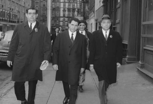 John “Sonny” Franzese (centre) is escorted to a New York police station in 1966 after his arrest on a 43-count gambling indictment.