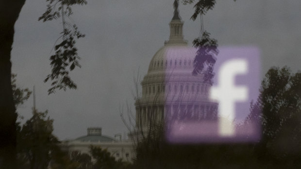 A Facebook logo seen in reflection on an advertising board near the US Capitol in Washington.