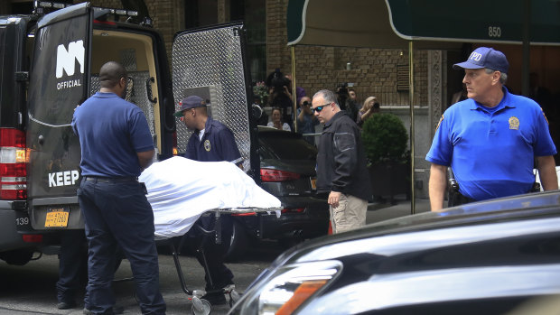 The body of designer Kate Spade is removed from her apartment building in New York on Tuesday.