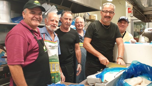 Cypriot Community of Queensland president Stathi Zambas and volunteers slicing half a tonne of calamari to sell at the annual Greek festival, Paniyiri.