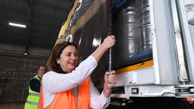 Queensland Premier Annastacia Palaszczuk and Minister for Agricultural Industry Development Mark Furner close the covers on a shipment of beer bound for outback Queensland.