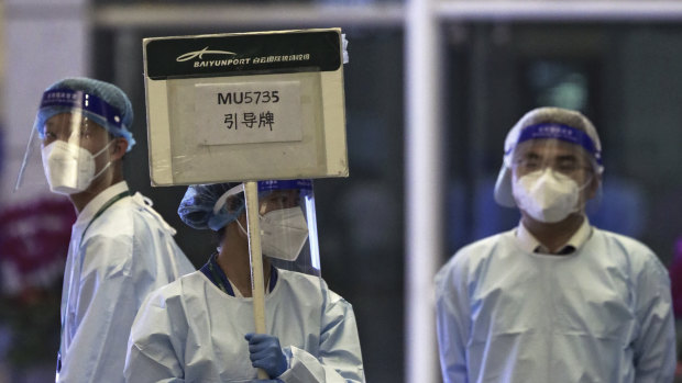 A worker from the China Eastern holds a signboard waiting to lead relatives of the victims aboard China Eastern’s flight MU5735 to a cordoned off area, in Guangzhou Baiyun International Airport in Guangzhou.