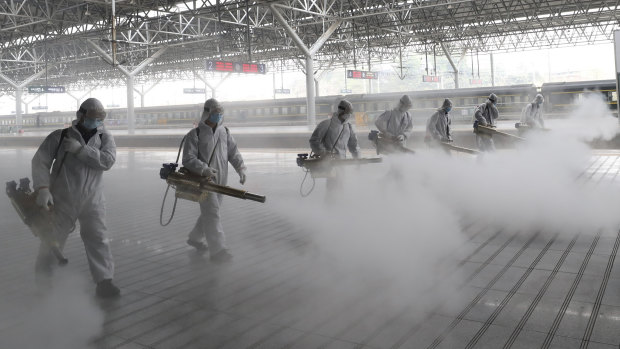 Firefighters conduct disinfection on the platform at a railway station before Wuhan's transport networks reopened in March. 