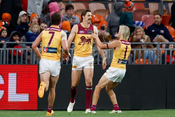 Joe Daniher of the Lions celebrates a goal with teammates.