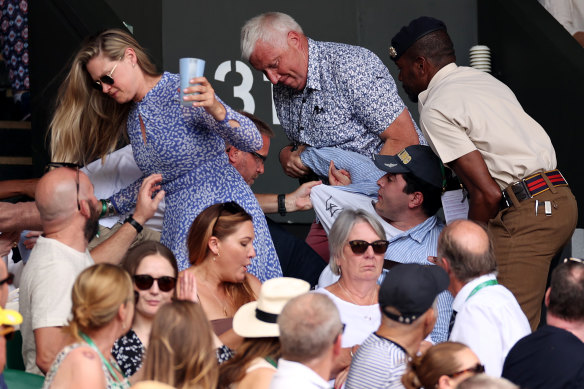 Security staff and spectators remove the 23-year-old from the stands during the men’s final at Wimbledon. 