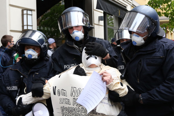 Police officers arrest a demonstrator protesting against the lockdown restrictions in Berlin on Saturday.