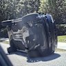 Woods is seen standing next to his overturned Range Rover in Jupiter Island, Florida.