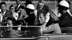 resident John F. Kennedy waves from his car in a motorcade approximately one minute before he was shot, on November 22, 1963, in Dallas. 
