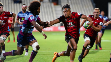 Leicester Faingaanuku of the Crusaders fends off Henry Speight of the Reds during their Super Rugby clash in Christchurch.