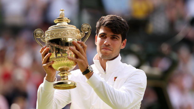 Carlos Alcaraz of Spain poses with the trophy after retaining his Wimbledon title.