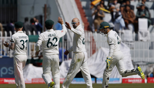 Nathan Lyon and teammates after grabbing the opening wicket.