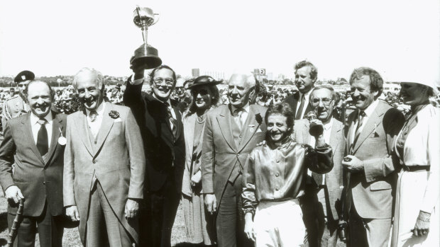 Lloyd Williams holds his first Melbourne Cup, won by Just  A Dash, trained by Tommy Smith, left, and ridden by Peter Cook.
