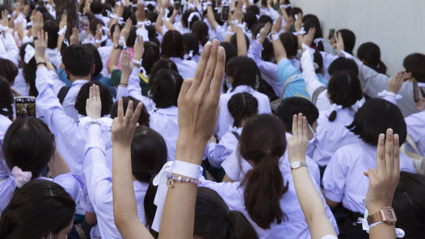 Pro-democracy students raise a three-finger salute, a symbol of resistance, during a protest rally in front of the Education Ministry in Bangkok.