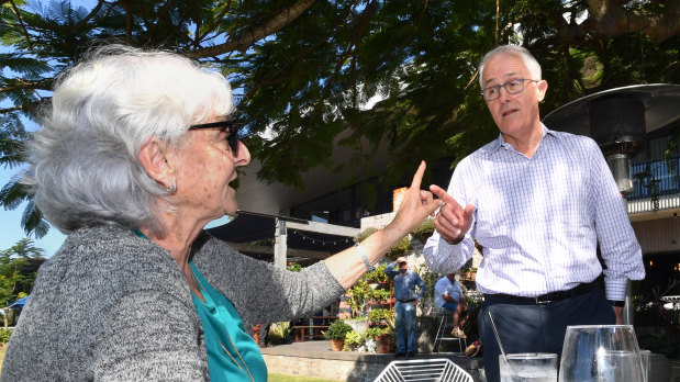 Prime Minister Malcolm Turnbull and local resident Toni Lea gesture at each other at the Sandstone Point Hotel ahead of the Longman byelection.