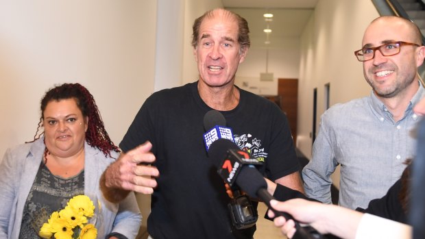 Australian filmmaker James Ricketson (centre), with his daughter Roxanne Holmes (left), arrives at Sydney International Airport.