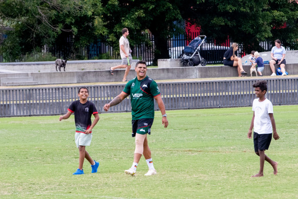 Latrell Mitchell is greeted by Indigenous fans, Jarell and Andrew Hamilton, at Redfern on Monday.