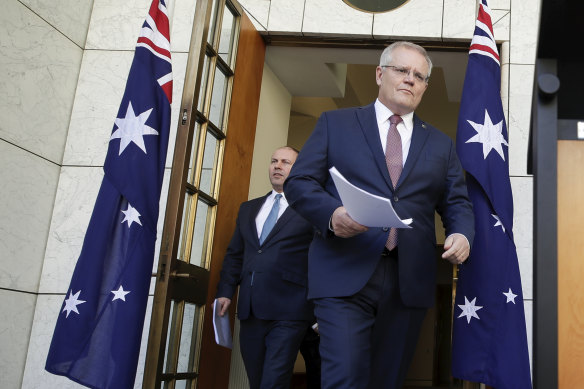 Scott Morrison and Josh Frydenberg arrive at a press conference to announce the superannuation withdrawal policy in 2020. The true cost of the program will not be known for 30 years.