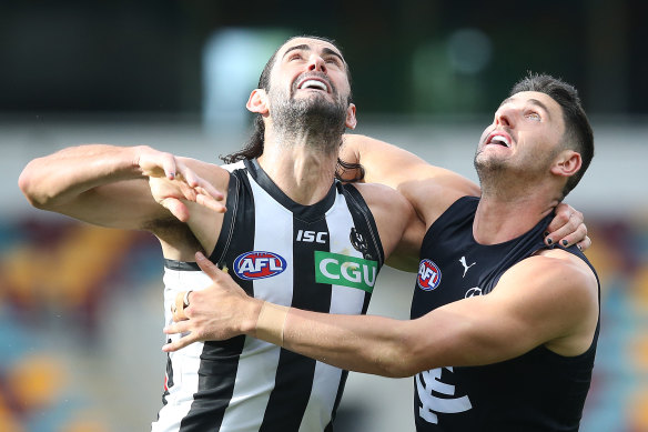 Brodie Grundy, left, and Marc Pittonet go head to head at the Gabba. 