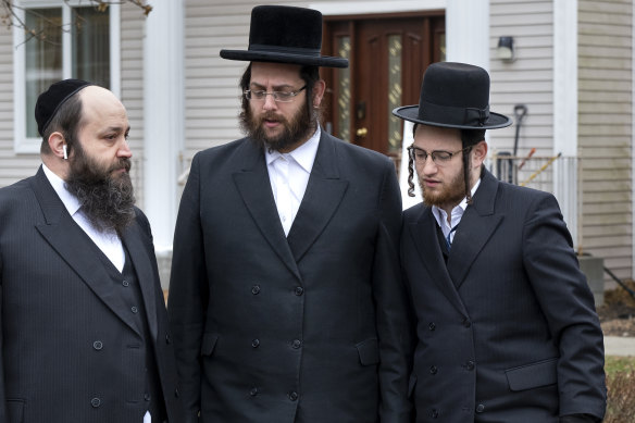 Community members gather outside a rabbi's residence in Monsey, New York, following a stabbing attack during a Hanukkah celebration. 