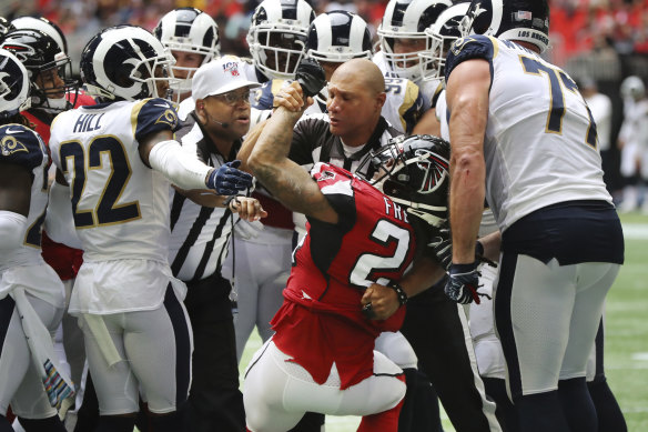 Officials restrain Devonta Freeman during a fight between the Falcons and the Los Angeles Rams. 