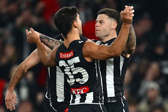 Jamie Elliott of the Magpies celebrates a goal with Nick Daicos.