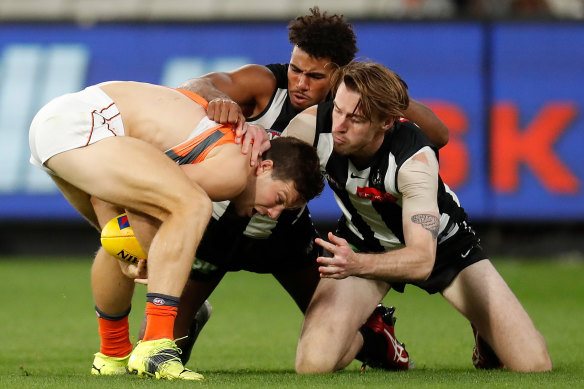 Isaac Quaynor (centre) comes to grips with GWS forward Toby Greene.