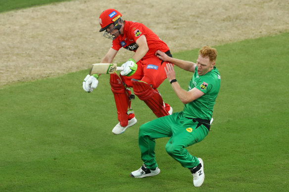 Demolition derby: Sam Harper of the Renegades and Stars bowler Liam Hatcher collide between the wickets.