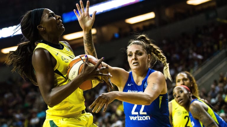 Cayla George (in blue) in action for Dallas Wings in the WNBA.
