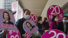 Supporters hold cutouts of a pro-Beijing candidate at a footbridge in Hong Kong on Sunday.