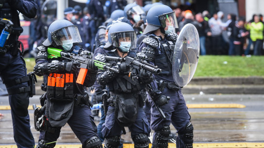 Police officers attempt to disperse protesters at a protest outside the CFMEU office on Elizabeth Street on Monday.