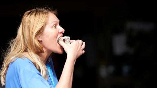 A National Health Service worker enjoys on of the lamingtons made by the Australian High Commission in London.