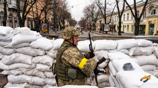 A Ukrainian soldier stands guard among the sandbags in downtown Odesa on Saturday. 