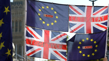 European Union (EU) and Union flags fly in front of the Houses of Parliament during the anti-Brexit People's Vote march in London, UK.