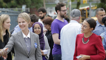 Democratic gubernatorial candidate Cynthia Nixon, centre, and congressional candidate Alexandria Ocasio-Cortez, right, greet voters and children outside a school while campaigning in New York.