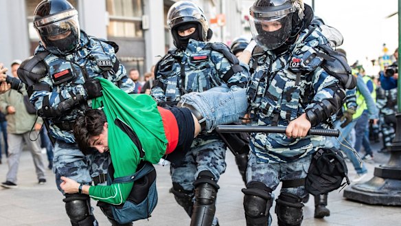 Police detain a man during Saturday's "unauthorised" protest in Moscow.