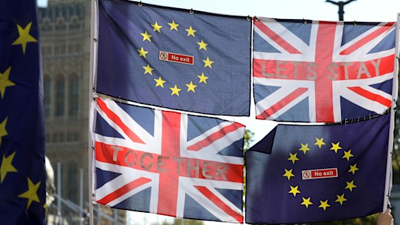 European Union (EU) and Union flags fly in front of the Houses of Parliament during the anti-Brexit People's Vote march in London, UK.