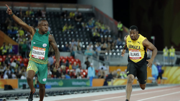 South Africa's Akani Simbine, left, celebrates after winning the men's 100m final, with Yohan Blake of Jamaica behind him. 