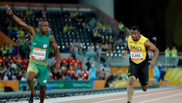 South Africa's Akani Simbine, left, celebrates after winning the men's 100m final, with Yohan Blake of Jamaica behind him. 