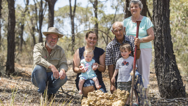 Historian John Tully, left, with a replica of the Welcome Stranger gold nugget, the crowbar that dug it up and descendants of co-finder John Deason: Suzie Deason, her father Arthur Deason, mother Stella and children Maisie and Henry. 