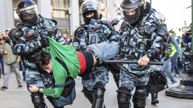 Police detain a man during Saturday's "unauthorised" protest in Moscow.