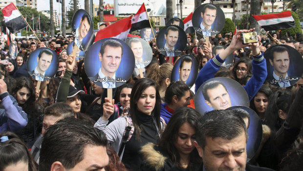 People hold Syrian flags and portraits of President Bashar al-Assad to protest US President Donald Trump stane on Israel earlier this year.