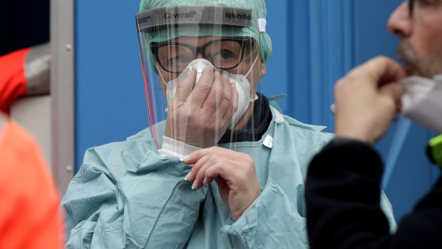 Medical staff wearing protective masks work at one of the emergency structures that were set up to ease procedures at the Brescia hospital, northern Italy.