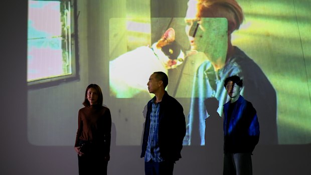 Apichatpong Weerasethakul (centre) with collaborators Pornpan Arayaveerasid (left) and Rueangrith Suntisuk with a Tilda Swinton image from the new installation. 