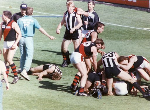 Collingwood’s Gavin Brown lies unconscious on the MCG turf as a brawl breaks out around him after the quarter-time siren.