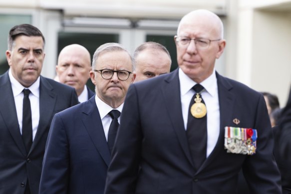 Prime Minister Anthony Albanese flanked by Governor-General David Hurley, right, and speaker Milton Dick. Opposition Leader Peter Dutton is in the background. 