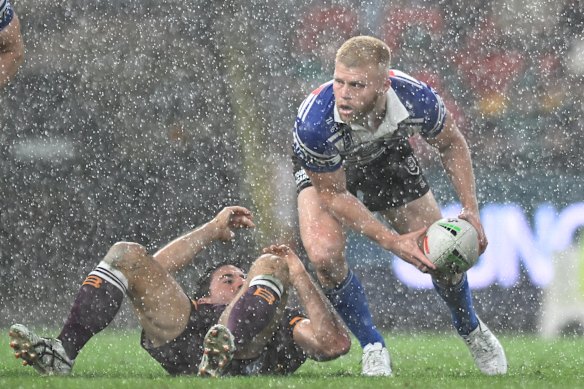 Bailey Hayward passes the ball in driving rain against the Broncos.