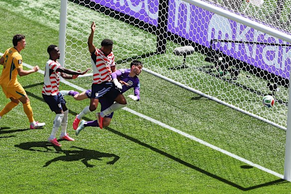 Alex Freeman heads the ball for a goal past Australia goalkeeper Patrick Beach.