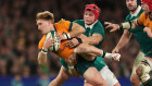 Tate McDermott of Australia is tackled by Craig Casey and Josh van der Flier.