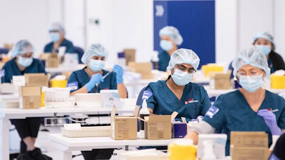 Staff preparing vaccines in the pharmacy area of the NSW Vaccination Centre at Homebush, Sydney.
